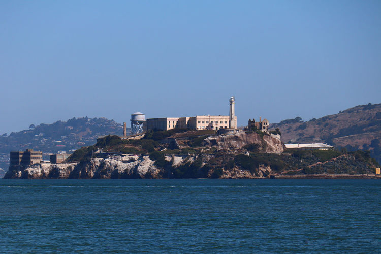 Alcatraz - san francisco - sea by buildings against clear blue sky