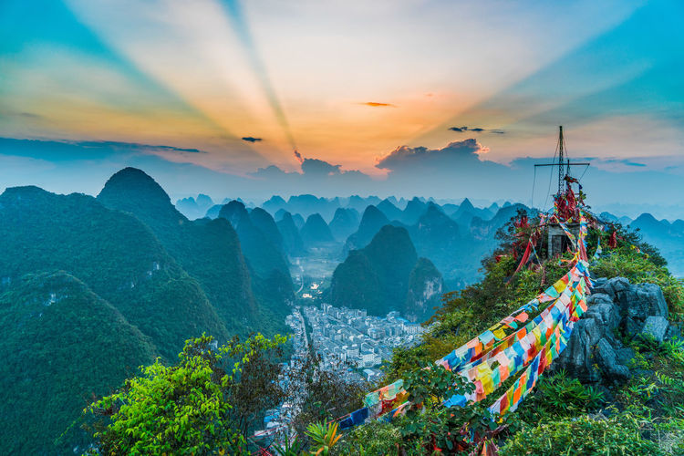Scenic view of sunset over karst mountains and prayer flag
