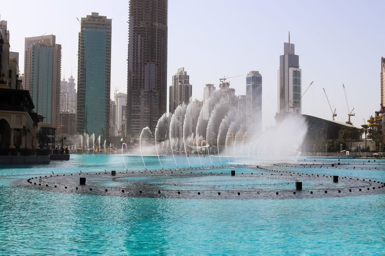 The dancing fountains downtown and in a man-made lake in dubai, uae in front of the burj khalifa