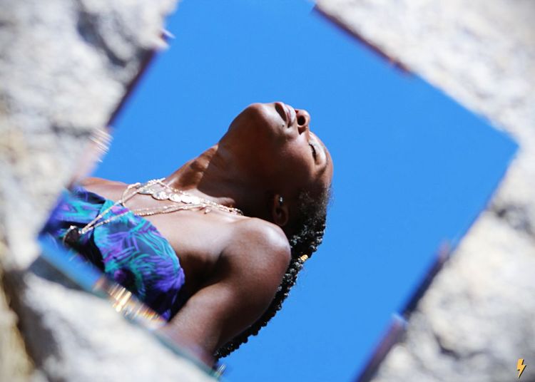 Low angle view of woman against blue sky