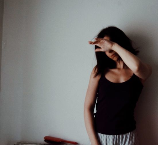 Midsection of woman standing against wall