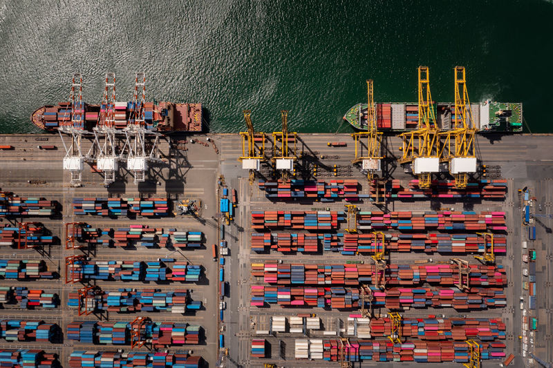 Container ship loading and unloading in deep sea port, aerial top view business service 