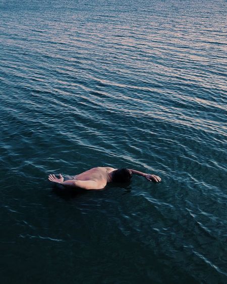 High angle view of person lying in sea