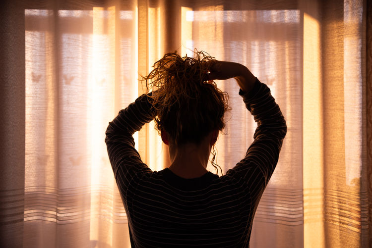 Rear view of woman standing at home