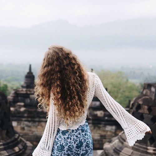 Rear view of woman standing by railing