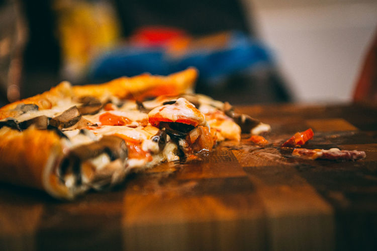 Selective focus of italian pizza, spices in grinders, bottle and glass of wine on wooden tabletop