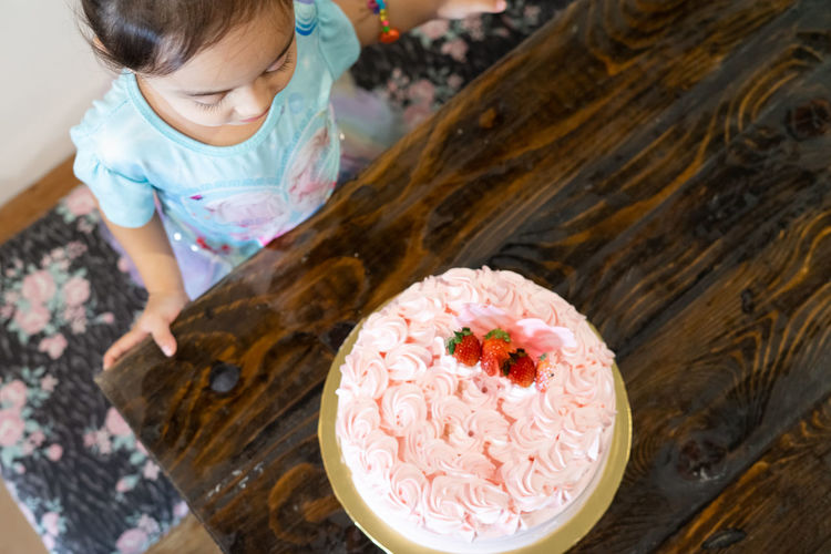High angle view of girl looking at cake
