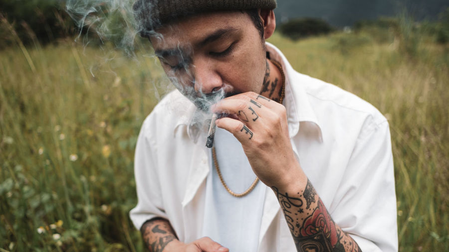 Side view of man smoking marijuana joint