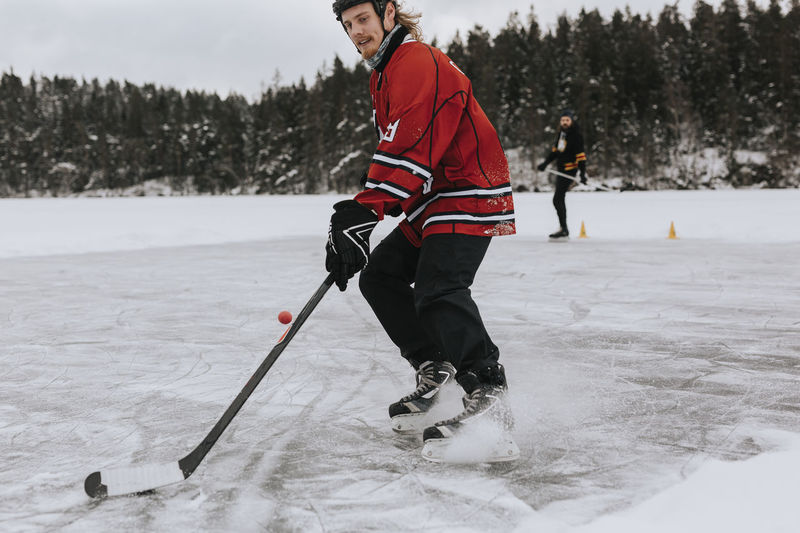 Man playing hockey on frozen lake