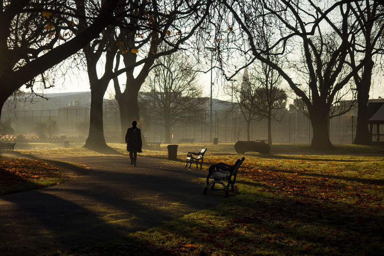 Man walking on bench in park