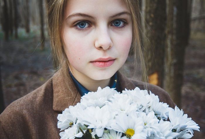 Close-up portrait of a young woman with bouquet