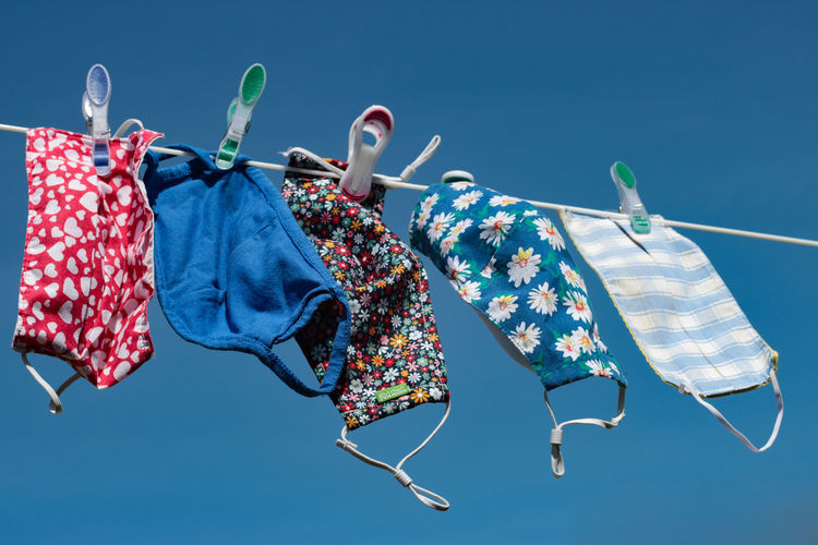 Low angle view of clothes hanging against blue sky