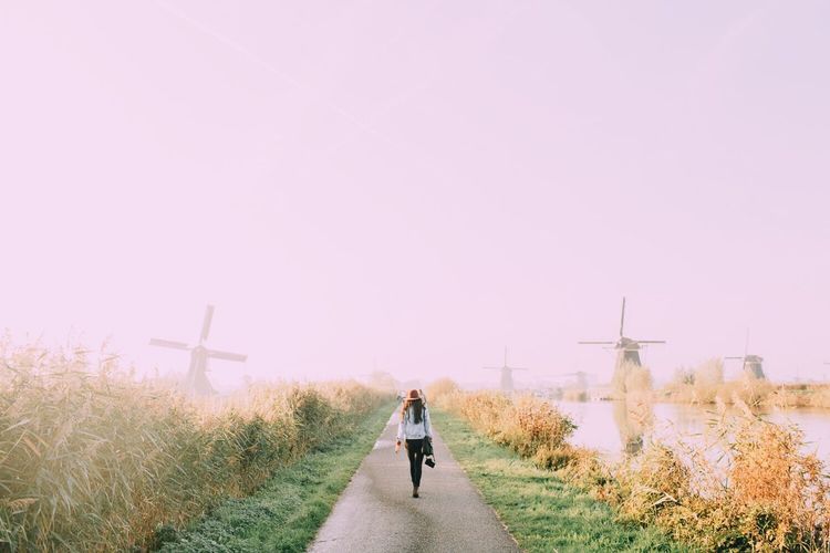 Rear view of woman walking on road in kinderdijk village