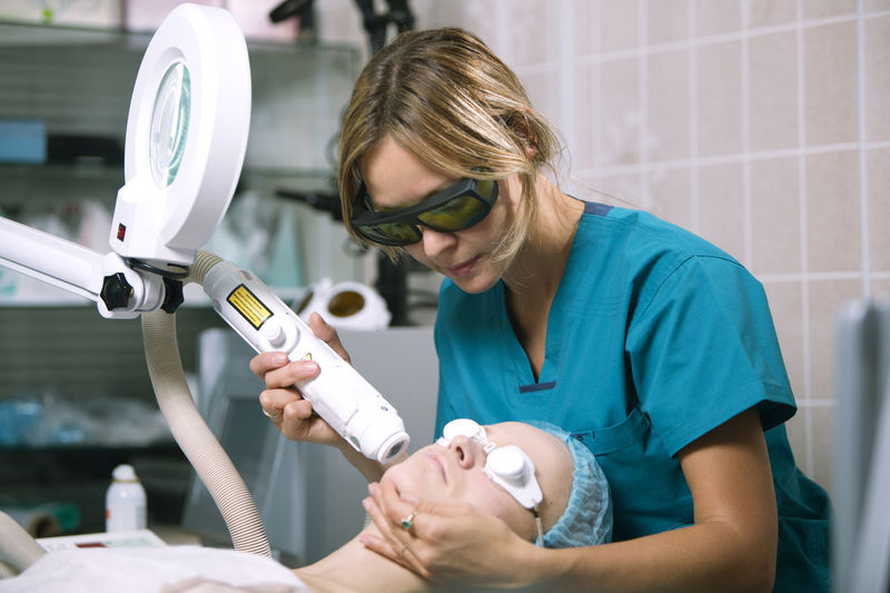 Close-up of woman getting beauty treatment from doctor