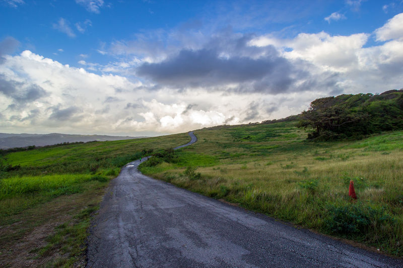 Road amidst field against sky
