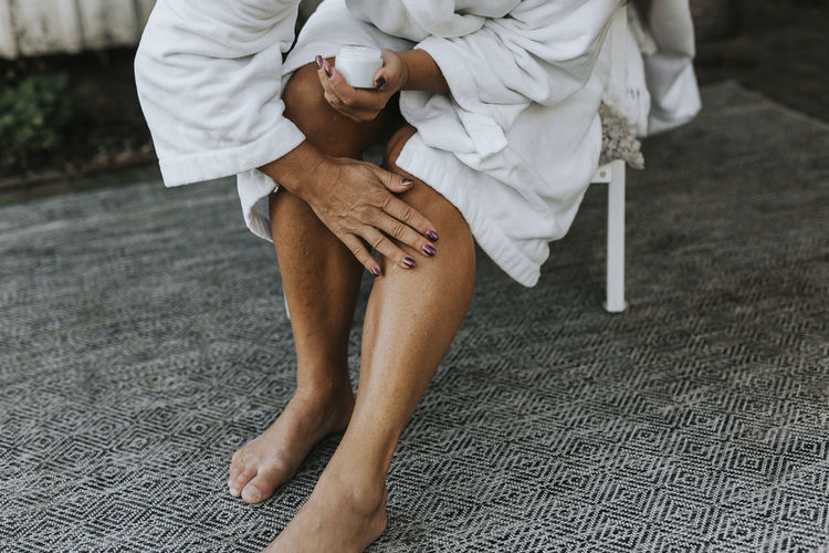 Woman applying moisturizer on her leg