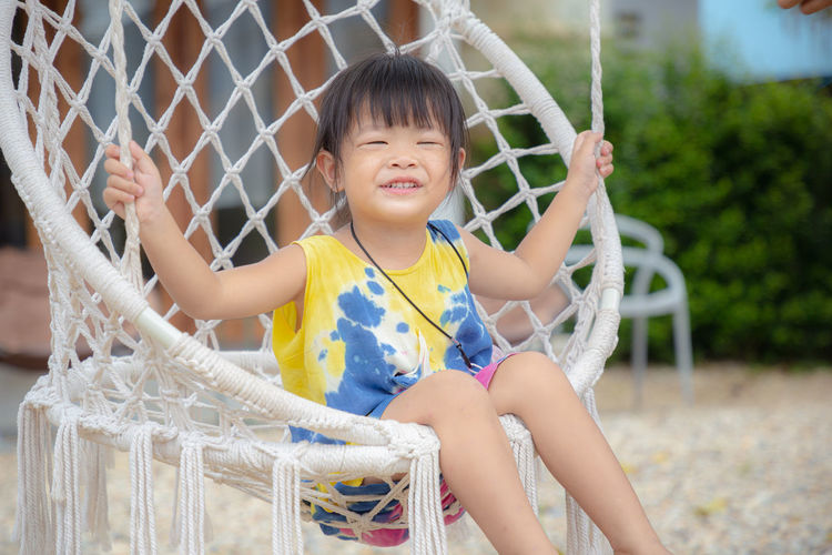 Smiling girl sitting on hammock