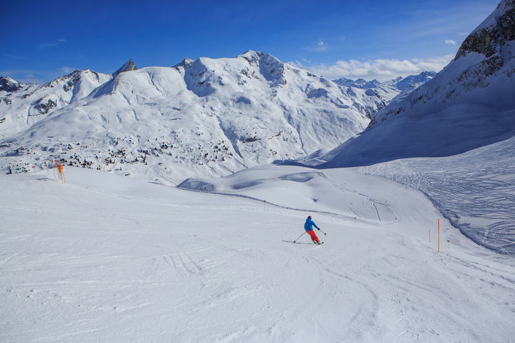 Men skiing on snowcapped mountain against sky
