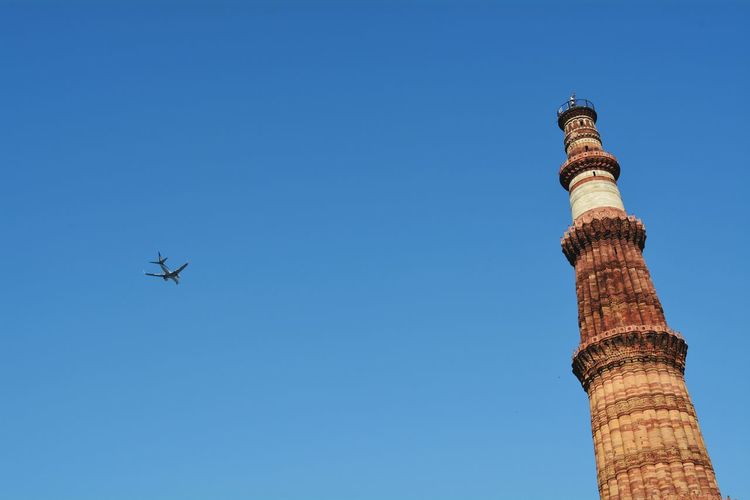 Low angle view of qutub minar against clear blue sky