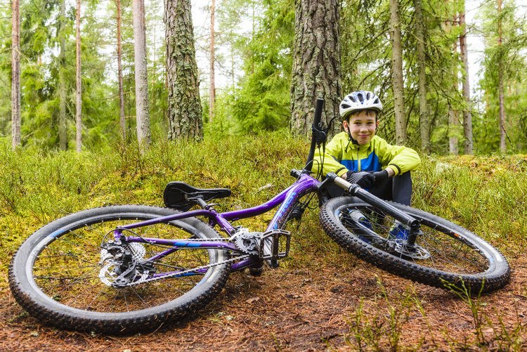 Boy with bike in forest