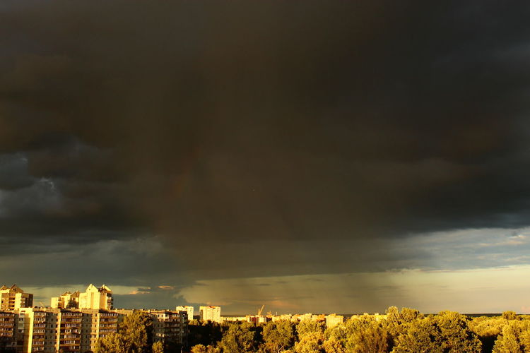 Panoramic view of city buildings against storm clouds