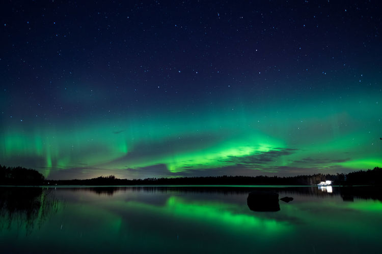 Scenic view of lake against sky at night