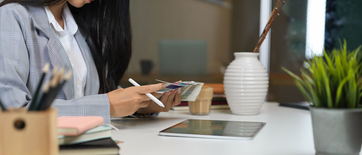 Midsection of woman using digital tablet in office