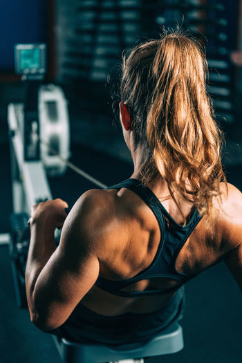 Rear view of woman exercising at gym 