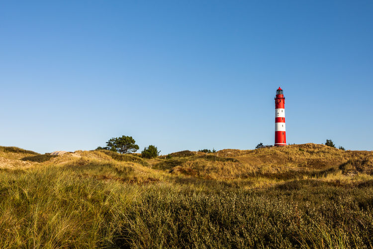 Lighthouse on field against sky, amrum, north sea, schleswig-holstein, germany  