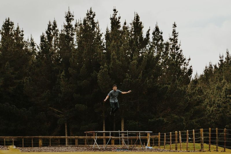 Man jumping on trampoline outdoors