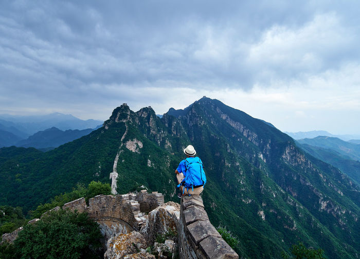 Man sitting against mountain on great wall of china