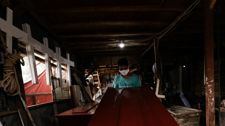 Workers at a small and medium-sized business producing coffins and crosses in jakarta
