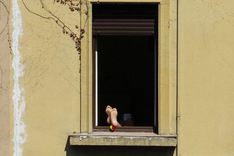 Side view of woman looking through window of building
