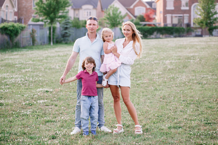Portrait of happy family standing on field