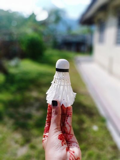 Midsection of woman holding shuttlecock 