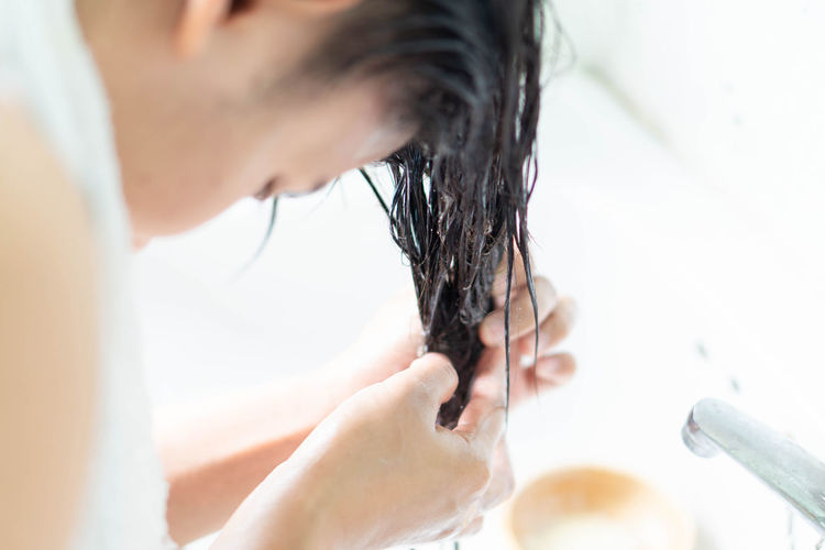 Close-up of woman washing hair in bathroom