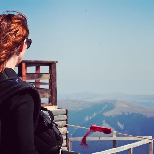 Woman looking at mountains against sky