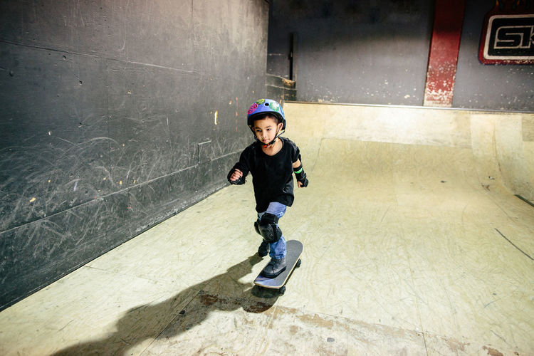 Focused young boy skateboards in an indoor skatepark