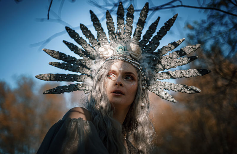 Woman wearing costume looking away standing outdoors