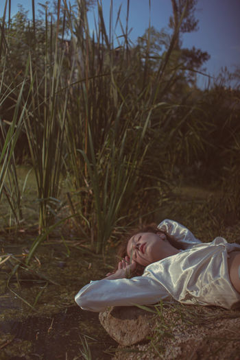 Portrait of woman lying on field