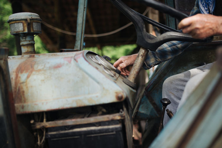 Old farmer driving a tractor closeup.