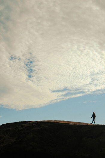 Silhouette man standing on land against sky