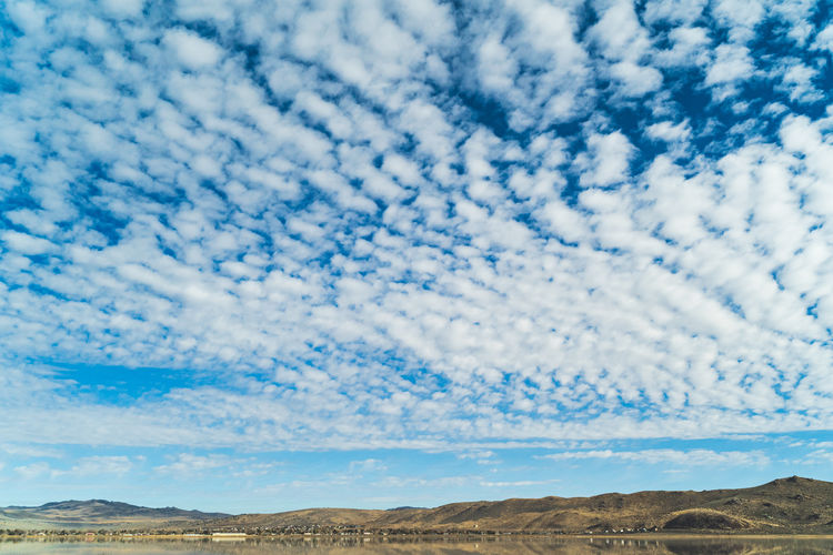 Beautiful arid rolling hills landscape in northern california against clouds and blue sky