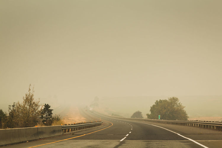 Driving down freeway amongst the smoke of  wildfires. daytime smoke climate change heat and fire.
