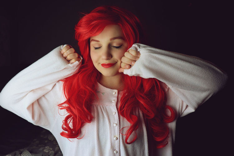 Portrait of beautiful young woman against black background