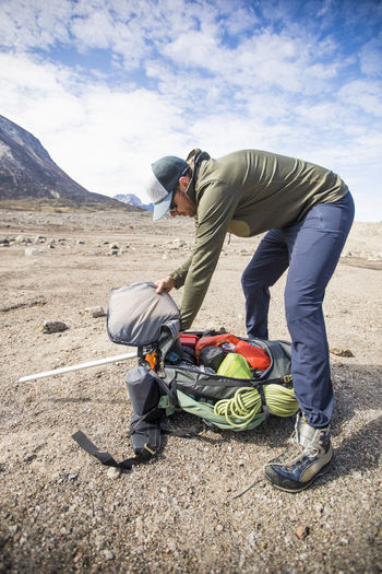 Backpacker packs his backpack before a long day of hiking