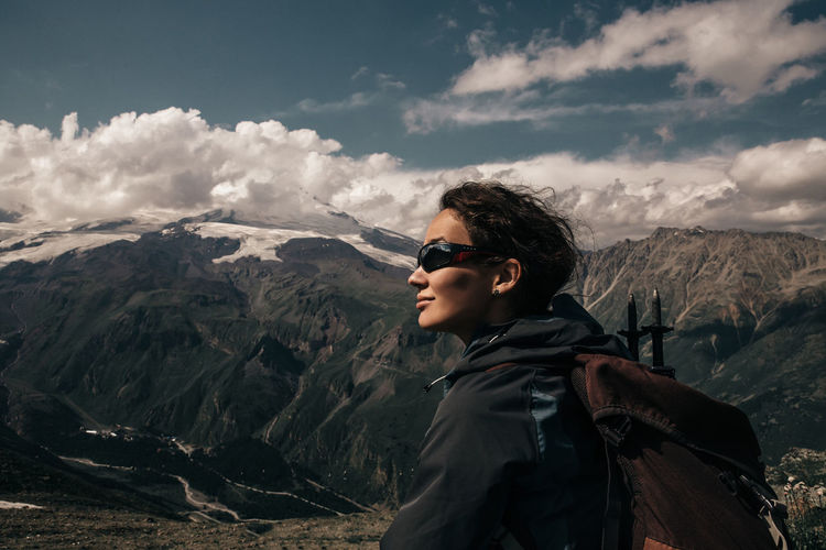 Woman wearing sunglasses hiking on mountain