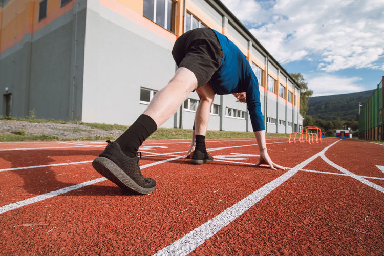 Detail of the body position of a professional athlete at the start of a 100m sprint