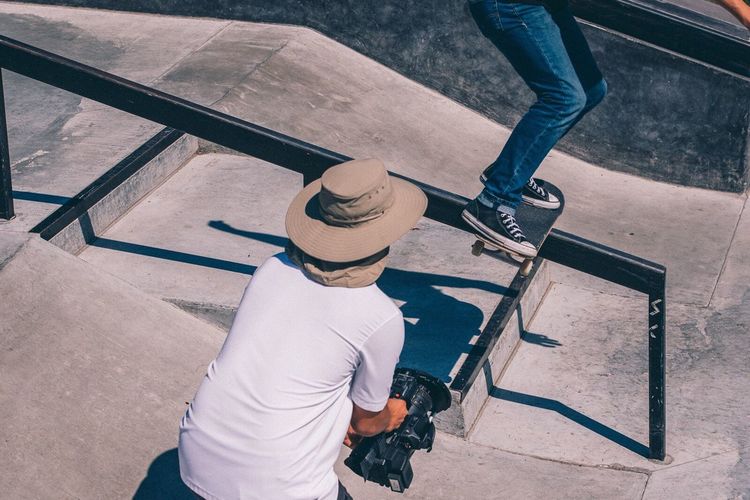 High angle view of man photographing camera on railing