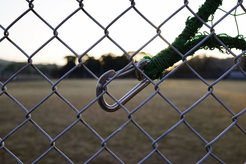 Close-up of carabiner on chainlink fence